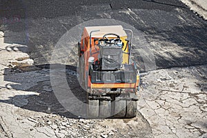 A small machine for laying a new asphalt.