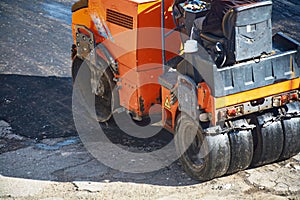 A small machine for laying a new asphalt.