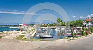 Small marina with moored motorboats in Zaton bay with Dinaric Alps in background  Croatia