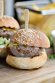 Small meat burger sliders on wooden table