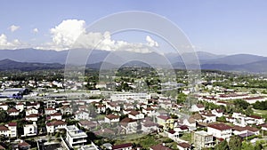 Small mediterranean town located by the sea. Clip. Panoramic aerial view of a beautiful green city and the sea on blue