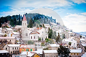 Small Mediterranean town on slopes of hill with church on top