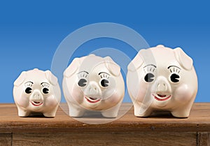 Small medium and large piggy banks on shelf