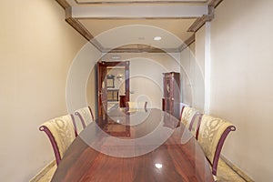 Small meeting room with a shiny wooden table with matching chairs