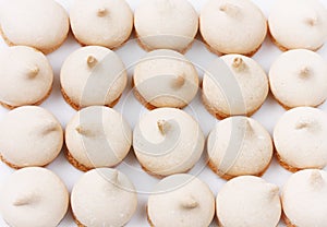 Small meringue cookies, arranged in row, homemade cakes