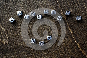 Small metal cubes with letters Valentine`s day lettering on wooden background