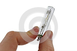 Small metal halide light bulb with GU10 10 mm mount held in right index finger and thumb