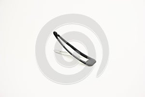 Small metal and plastic cover flat hair pin close up studio shot isolated on white background