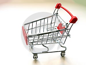Small metal toy grocery cart from a supermarket, isolate on a white background.