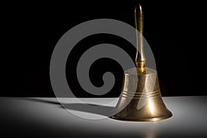 A small metallic hand bell black background