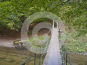 Small metallic pedestrian bridge over Cerna river, Romania, Europe