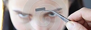 Small microcircuit chip in front of woman's head