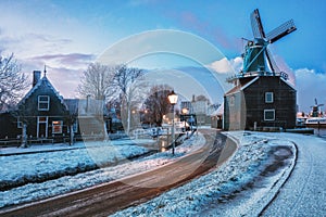 Small mill and typical Zaanse houses on the Zaans Schans in winter located on the river De Zaan
