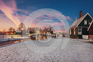 Small mill and typical Zaanse houses on the Zaans Schans in winter located on the river De Zaan