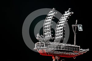A model of famous ancient Korean ironclad war ship. Korean turtle ship on a black background. Black and white and red