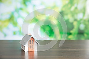 small model house with green bokeh background