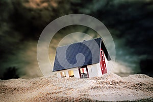 Small model of house in sand