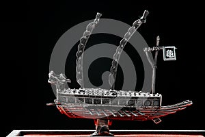 A small model of Korean ironclad war ship. Korean turtle ship on a black background. Black and white and red