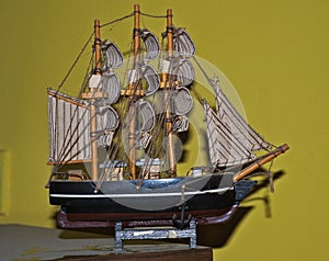Small model of sailing ship on dirty table...