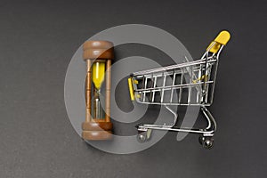 Small model shopping cart over black background studio