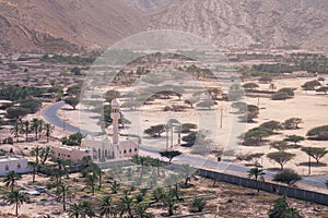 Small mosque in the rural area of Musandam province Suburbs of Bukha village, Oman. Palm trees in the desert under steep