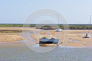 Small motor boat beached at low tide in Wells-next-the-Sea