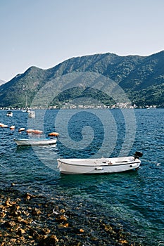 Small motor boats sway on the waves moored near the shore