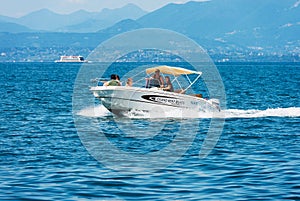 Small Motorboat with a Family on Board in motion on Lake Garda - Italy
