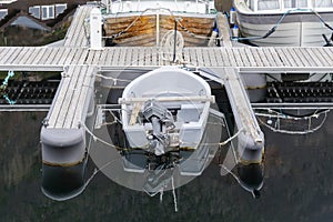 Small motorboat moored at a quiet dock on an overcast day