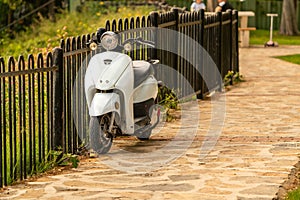 Small motorcycle parked by the fence