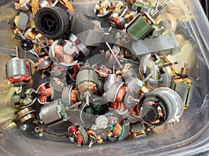 Small electric motors in container showing windings and shafts photo