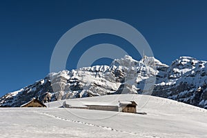 Small mountain huts on an alp in front of the Saentis massif in winter, Canton Appenzell-Ausserrhoden, Switzerland