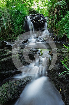 Small mountain waterfall on the rocks.Slow shutter speed, motion photography.