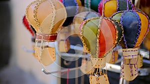 Small multi-colored toy balloons hang on counter in store and wait for their buyer. bunch of toy balls made of leather