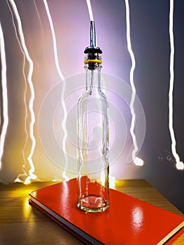 Small narrow bottle with bartender pourer on table