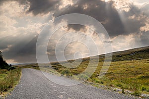 Small narrow country road in Connemara, county Galway, Ireland. Dramatic sky. Irish landscape. Beautiful nature scene