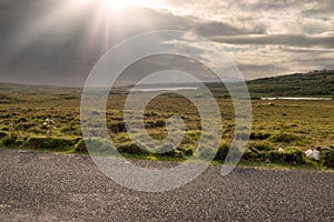 Small narrow country road in Connemara, county Galway, Ireland. Dramatic sky. Irish landscape. Beautiful nature scene