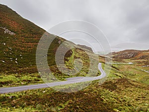 Small narrow road in a stunning mountain area. Mamore gap, county Donegal, Ireland. Amazing drive with rough wild nature scenery.