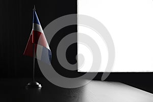 Small national flag of the Dominicana on a black background