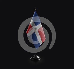 Small national flag of the Dominicana on a black background