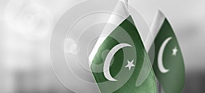 Small national flags of the Pakistan on a light blurry background photo