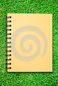 Small notebook on green grass field