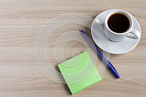 A small Notepad, a pen, and a Cup of coffee on the table.The concept of planning for the day