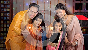 Small nuclear family burning firecrackers / Phuljhadis with their children - festive season