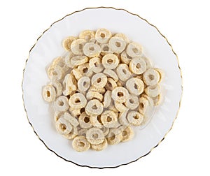 Small oat flakes in form rings in plate on white