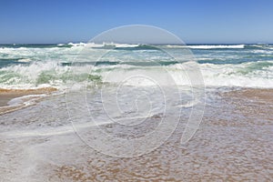 Small ocean waves crashing on a beach