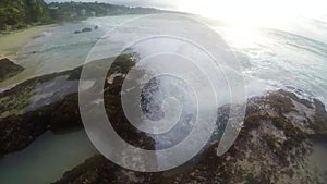 A small oceanic geyser on the beach, water is recruited and spraying in all directions in slow motion