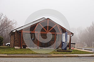 A small office building on a foggy morning day