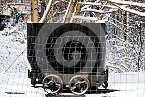 Small old black coal wagon in a winter landscape
