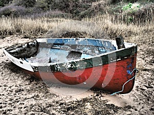 Small old broken boat on the beach by the sea